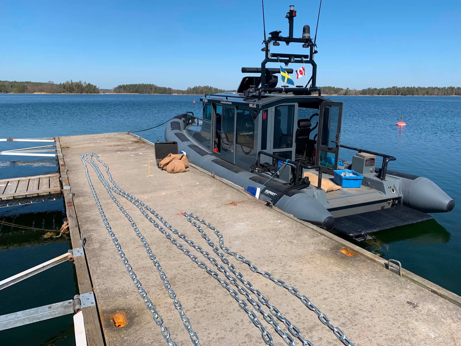 Arbetsbåt vid brygga med materiel inför ett uppdrag i skärgården
